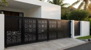 Pagar rumah minimalis modern dengan hollow galvanis coating hitam dan motif laser cutting, berdiri di atas pondasi beton dengan celah drainase